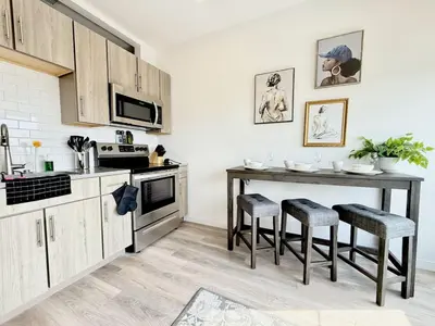 a kitchen with a table and stools in it at Philly Central King 1BR with Gym in Philadelphia