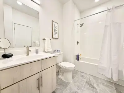a white bathroom with a sink and a toilet at Philly Central King 1BR with Gym in Philadelphia