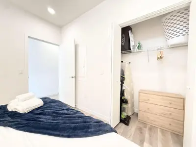 a white bedroom with a bed and a closet at Philly Central King 1BR with Gym in Philadelphia