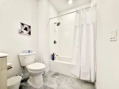 a white bathroom with a toilet and a shower at 1BR Apt King Bed FREE Parking Gym - RoofTop 609 in Philadelphia