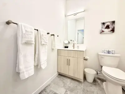 a white bathroom with a toilet and a sink at 1BR Apt King Bed FREE Parking Gym - RoofTop 609 in Philadelphia