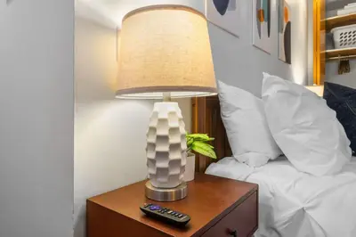 a lamp on a table next to a bed at Quaint and Stylish APT with King Bed for Long Term Stay in Philadelphia