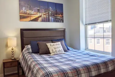a bedroom with a bed with a blanket and a picture at Old City Apt Near Independent Hall and Liberty Bell in Philadelphia