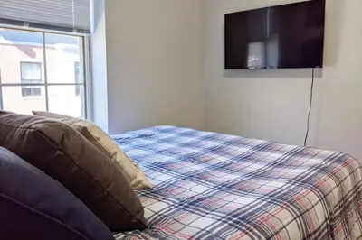 a bedroom with a bed and a tv on the wall at Old City Apt Near Independent Hall and Liberty Bell in Philadelphia