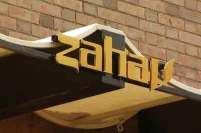 a sign for a restaurant hanging from a brick wall at Old City Apt Near Independent Hall and Liberty Bell in Philadelphia