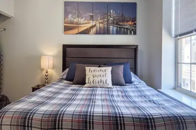 a bedroom with a bed with a plaid blanket at Old City Apt Near Independent Hall and Liberty Bell in Philadelphia