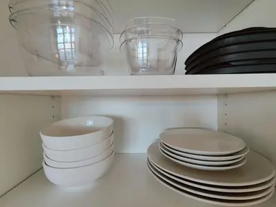 a bunch of plates and bowls on a shelf at Studio Apt Near Temple Unit with Free Parking for Extended Stays in Philadelphia