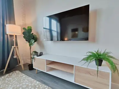 a living room with a tv on a white wall at Studio Apt Near Temple Unit with Free Parking for Extended Stays in Philadelphia