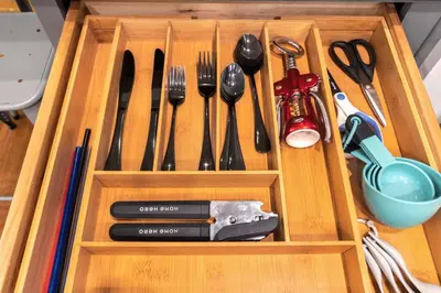 a wooden drawer with utensils in a wooden box at Chic Apartment with King Bed in Old City in Philadelphia