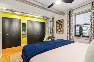 a bedroom with a bed and a yellow wall at Chic Apartment with King Bed in Old City in Philadelphia