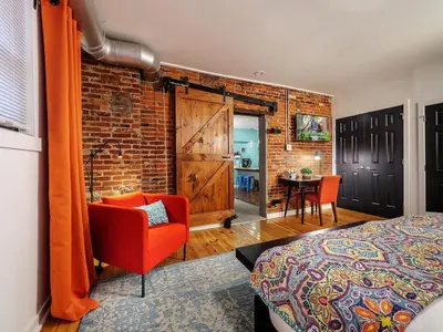 a bedroom with a red chair and a brick wall at Charming 1BR in Philly with Courtyard View in Philadelphia