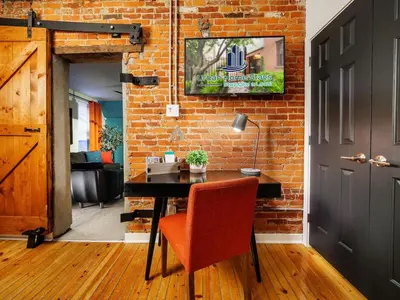 a room with a desk with a chair and a brick wall at Charming 1BR in Philly with Courtyard View in Philadelphia