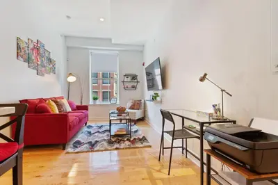 a living room with a red couch and a table at Old City Apartment with Full Kitchen in Philadelphia