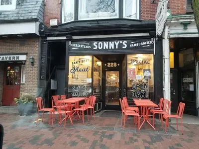 a group of red tables and chairs in front of a store at Old City Apartment with Full Kitchen in Philadelphia