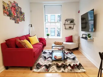 a living room with a red couch and a table at Old City Apartment with Full Kitchen in Philadelphia