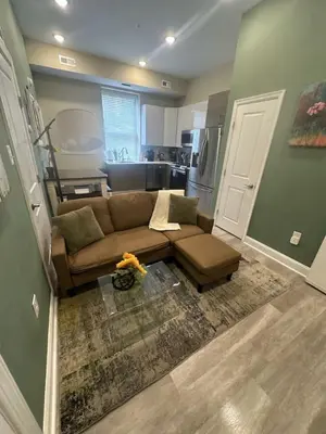 a living room with a couch and a kitchen at Downtown Philly 1BR with Stunning Views in Philadelphia