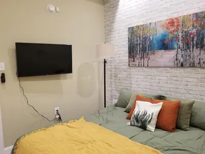 a living room with a couch with a tv on a wall at Downtown Philly 1BR with Stunning Views in Philadelphia