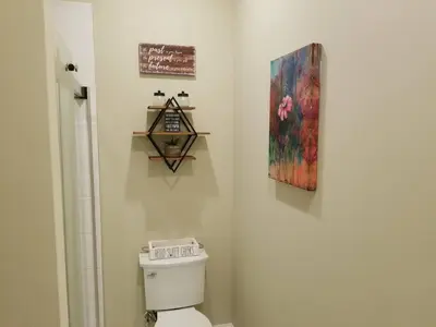 a bathroom with a toilet and a painting on the wall at Downtown Philly 1BR with Stunning Views in Philadelphia