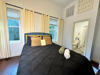 a bedroom with a large black bed with pillows at BP STAYS - Hotel-Style, No Host, Professionally Managed ID302 in Jersey City