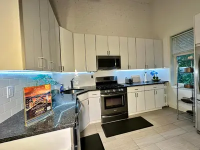 a kitchen with white cabinets and a stove top oven at BP STAYS - Hotel-Style, No Host, Professionally Managed ID302 in Jersey City