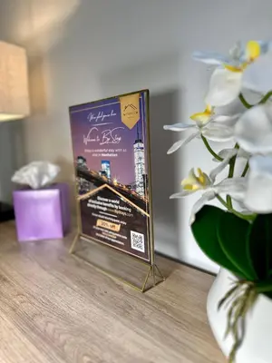a book sitting on a table next to a vase with flowers at BP STAYS - Hotel-Style, No Host, Professionally Managed ID302 in Jersey City