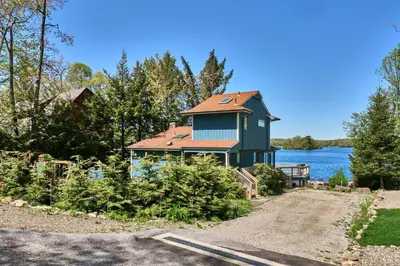 a house on the shore of a body of water at Dream Lakefront Escape + Beach/Ski/Golf near NYC in Vernon Township