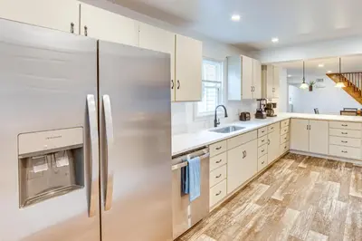 a kitchen with white cabinets and a stainless steel refrigerator at York Farmhouse Hideaway Near Lake Redman in York