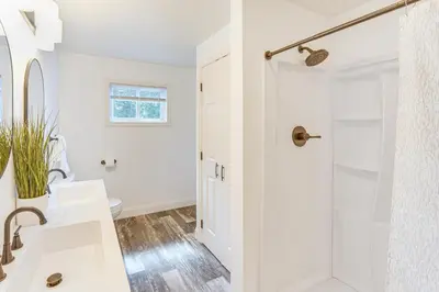 a white bathroom with a shower and a sink at York Farmhouse Hideaway Near Lake Redman in York