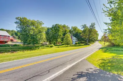 an empty road in a residential neighborhood with houses at York Farmhouse Hideaway Near Lake Redman in York