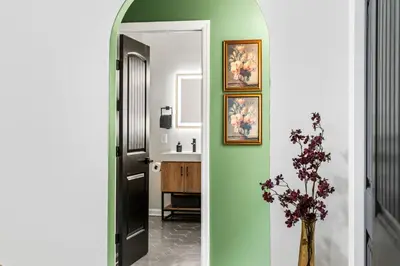 a hallway with a vase of flowers and a bathroom at Pocono Speak Easy Hot Tub Golf Simulator 1920 Bar in East Stroudsburg