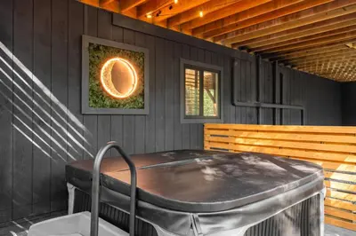a jacuzzi tub sitting on the side of a house at Pocono Speak Easy Hot Tub Golf Simulator 1920 Bar in East Stroudsburg