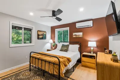 a bedroom with a bed and two windows at Pocono Speak Easy Hot Tub Golf Simulator 1920 Bar in East Stroudsburg