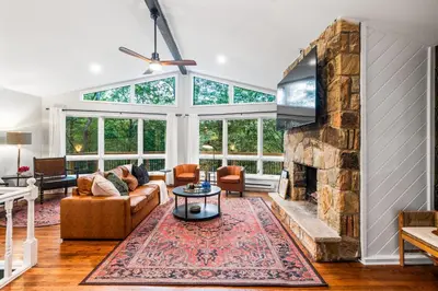 a living room with a large stone fireplace at Pocono Speak Easy Hot Tub Golf Simulator 1920 Bar in East Stroudsburg