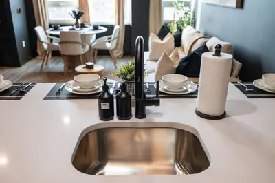 a kitchen with a sink and a living room at Luxe 1br- Free Parking-King Bed in East Orange