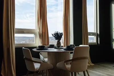 a dining room table with chairs and a vase with flowers at Luxe 1br- Free Parking-King Bed in East Orange