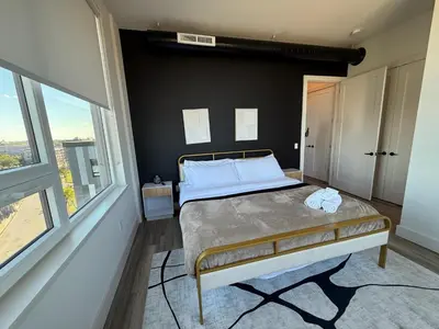 a bedroom with a bed and a large window at NYC View, Free Parking, 2bath in East Orange