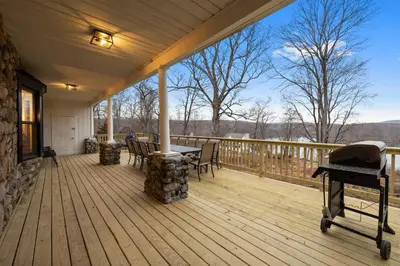 a porch with a table and chairs on a deck at Lakeview-Sleeps 12-King Suites-7BR - Firepit in Monroe