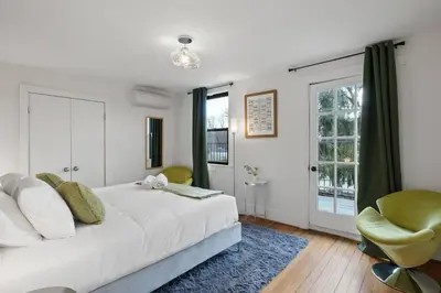 a white bedroom with a bed and a chair at Lakeview-Sleeps 12-King Suites-7BR - Firepit in Monroe
