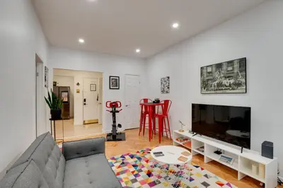 a living room with a couch and a tv at Cozy Condo Jersey City in Jersey City
