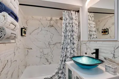 a bathroom with a blue sink and a shower at Cozy Condo Jersey City in Jersey City