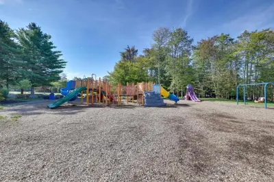 a playground in a park with a slide at Family Cabin with Hot Tub Game Room Tobyhanna in Tobyhanna