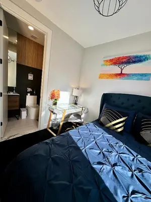 a bedroom with a blue bed and a bathroom at BP STAYS - Hotel-Style, No Host, Professionally Managed ID286 in Jersey City