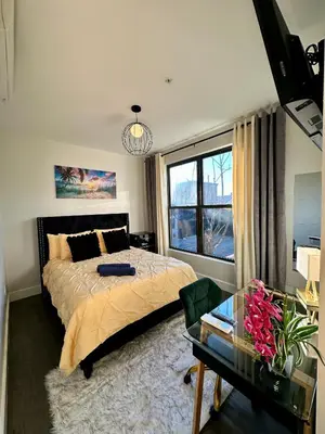 a bedroom with a bed and a table and a window at BP STAYS - Hotel-Style, No Host, Professionally Managed ID286 in Jersey City