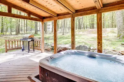 a hot tub on a wooden deck with a grill at Long Pond Log Cabin with Hot Tub Soaks and Outdoor Fun in Long Pond
