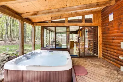 a jacuzzi tub in the middle of a house at Long Pond Log Cabin with Hot Tub Soaks and Outdoor Fun in Long Pond