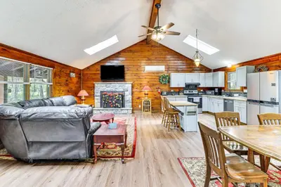 a living room and kitchen with a couch and a table at Long Pond Log Cabin with Hot Tub Soaks and Outdoor Fun in Long Pond