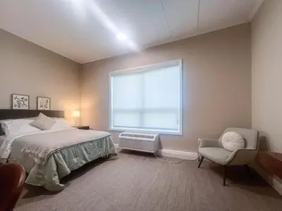 a bedroom with a bed and a chair and a window at 401 Modern Brand New Studio Apartment in Old Bridge
