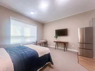 a bedroom with a bed and a large window at 416 Modern Brand New Studio Apartment in Old Bridge