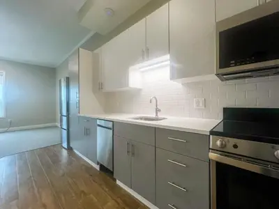 a kitchen with white cabinets and a sink at 416 Modern Brand New Studio Apartment in Old Bridge