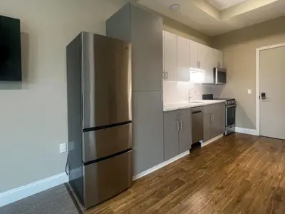 a large kitchen with a stainless steel refrigerator at 413 Modern Brand New Studio Apartment in Old Bridge